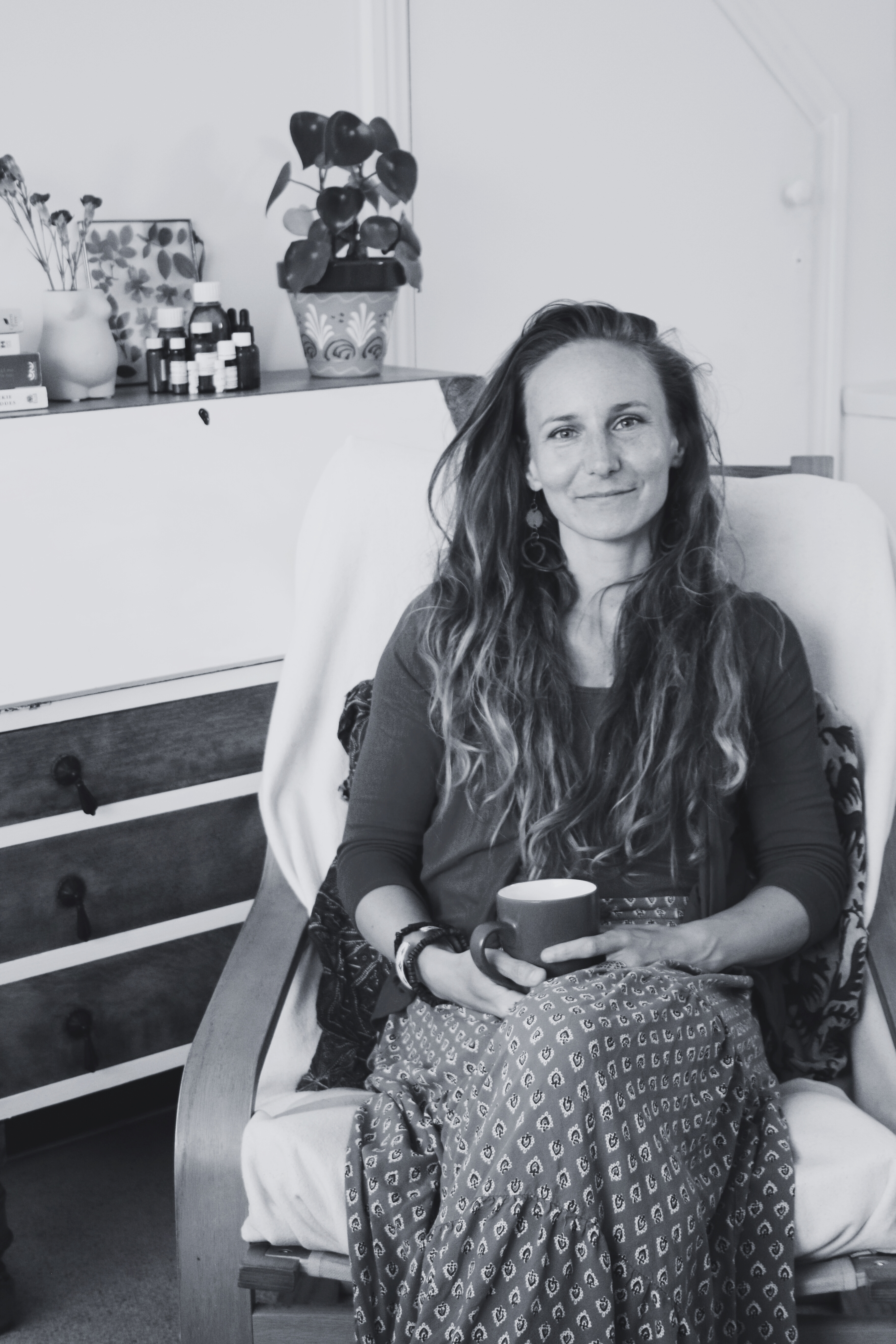 Anna Bihari, holistic therapist, smiling and seated in a calm and welcoming consultation room.