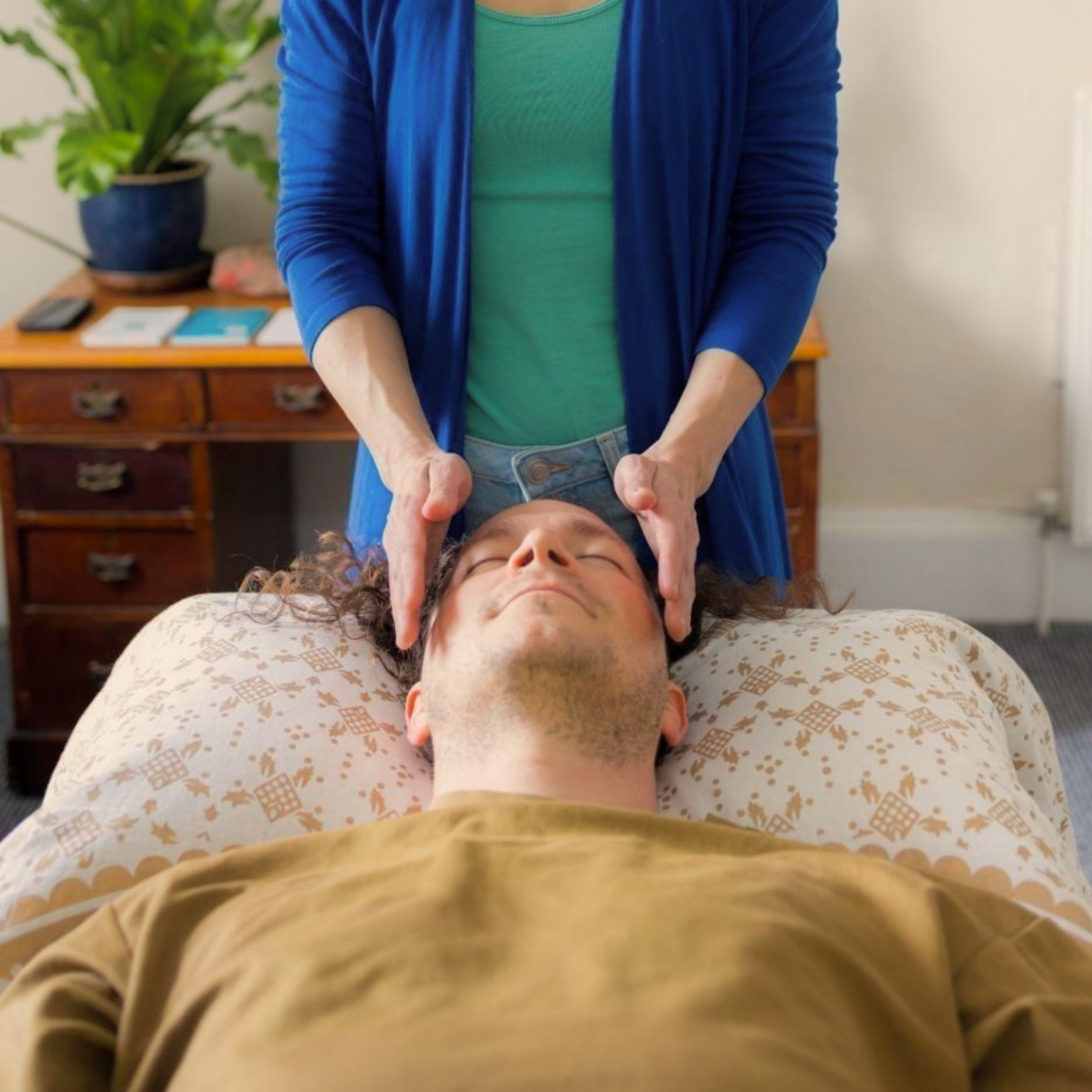 Anna Bihari Brighton energy healer giving a Reiki session to client laying on a treatment couch