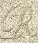 Close-up of the Sahara cast stone finish, a sandy color with a letter 'R' carved to show texture.