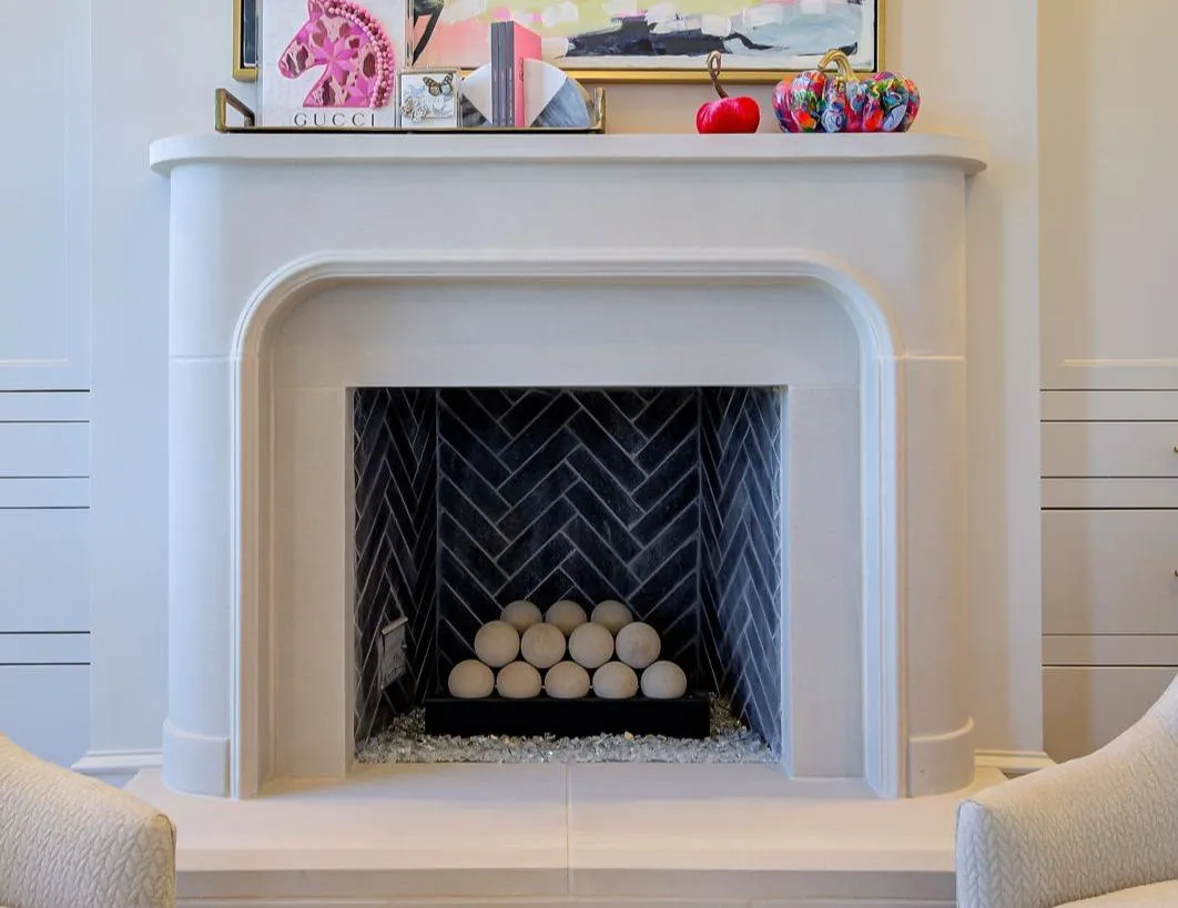 A luxurious living room centered around the Gusto Divino, an arched stone fireplace with a chic herringbone interior.