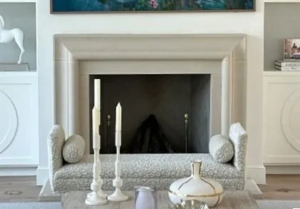 The grand Medici fireplace, featuring a classically molded stone mantel and a traditional wood-burning firebox with brass andirons..