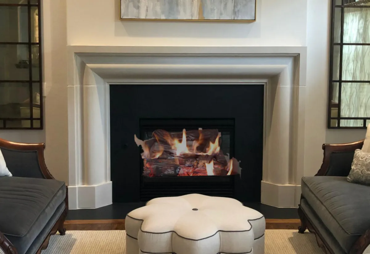 The Zorio classic gas fireplace, featuring a substantial stone surround with deep architectural molding and a realistic burning log set.