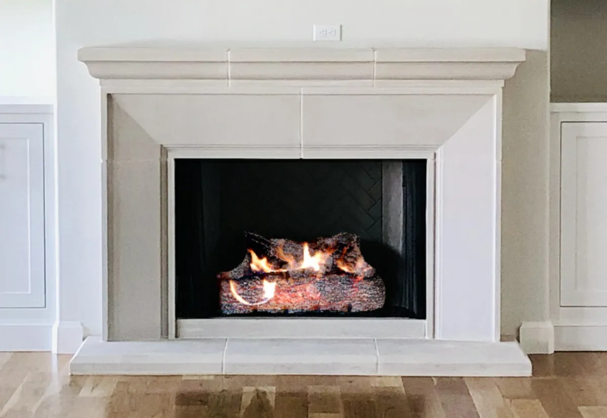 The elegant Pisa fireplace, blending classic design with a modern herringbone firebox and a realistic, glowing gas log set.