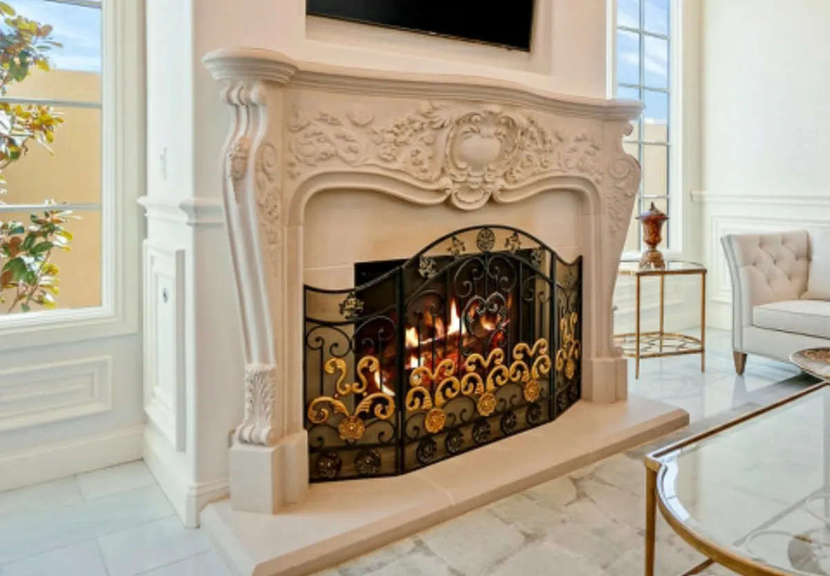 The opulent Rococo style fireplace, featuring elaborate hand-carved scrollwork, elegant cabriole legs, and a decorative fire screen.