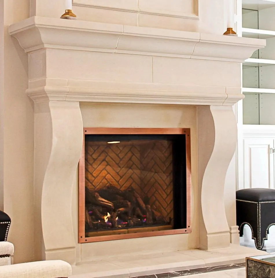 The Dijon, a French provincial fireplace showcasing gracefully curved stone legs, a warm herringbone brick interior, and elegant copper trim.