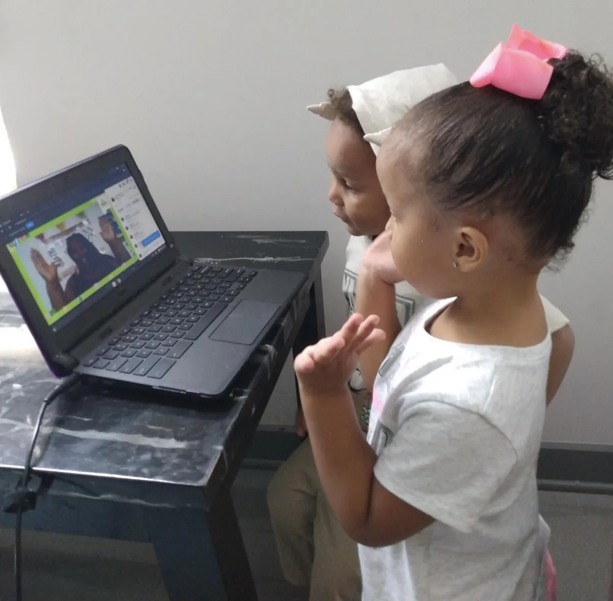 Teacher engaging with children using a loris puppet in interactive online preschool program