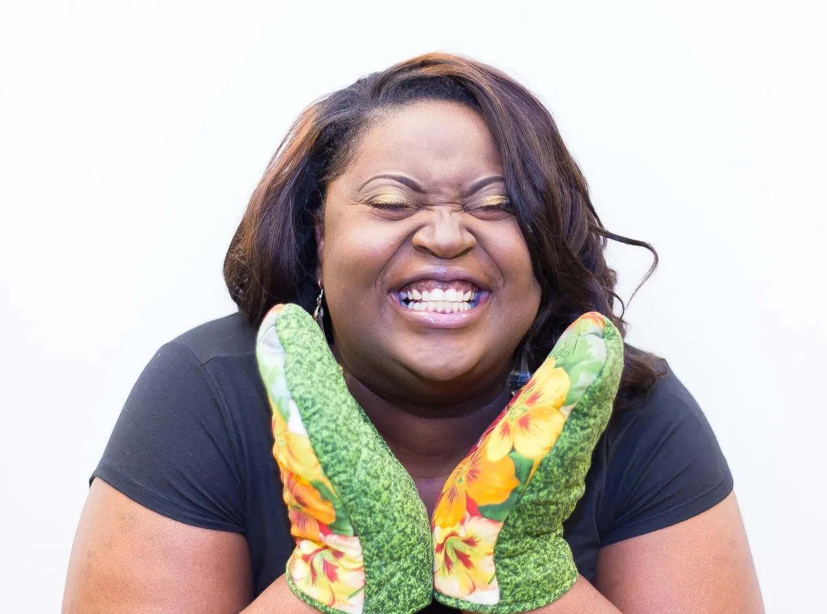 Teacher wearing oven mitts demonstrating a fun and interactive family cooking class