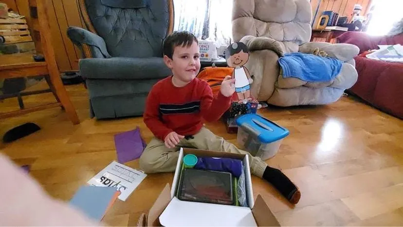 Excited student holding up their preschool weather buddy from their welcome kit