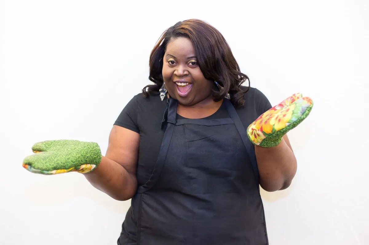 Teacher wearing oven mitts demonstrating a fun and interactive family cooking class