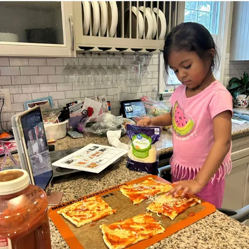 Teacher wearing oven mitts demonstrating a fun and interactive family cooking class