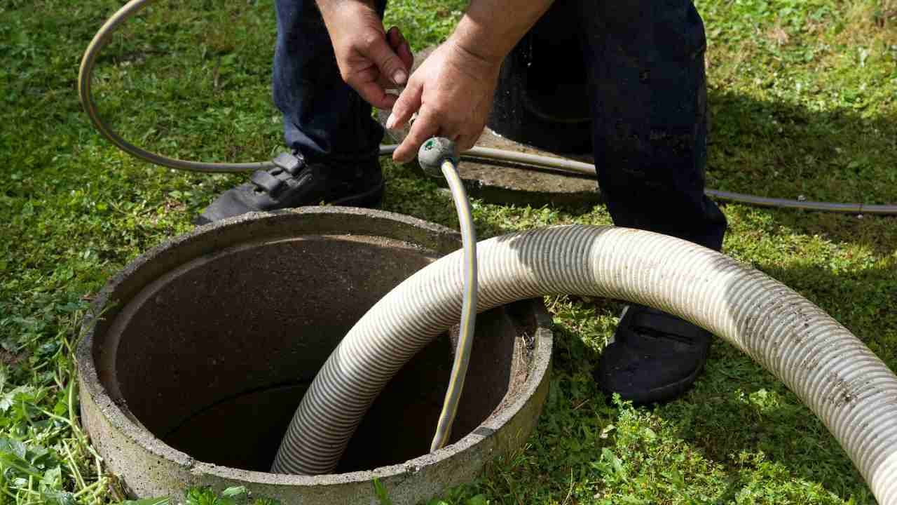 Man pumping out water into septic tank