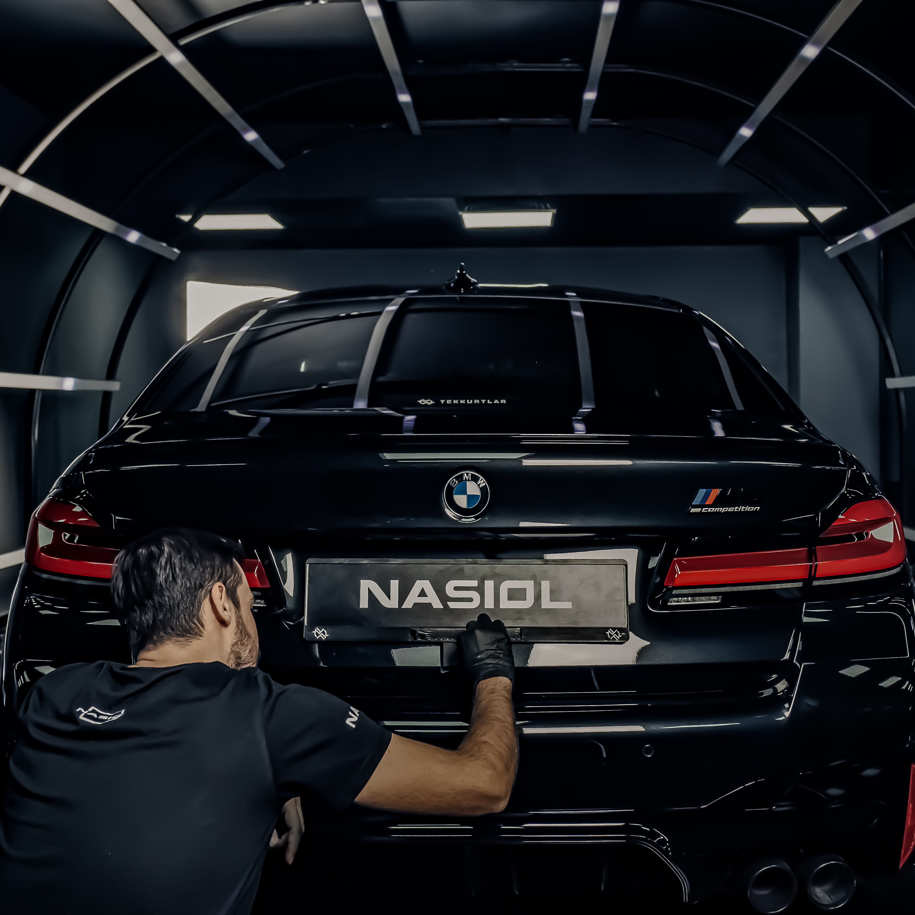 a man bending over next to a car on a checkered floor