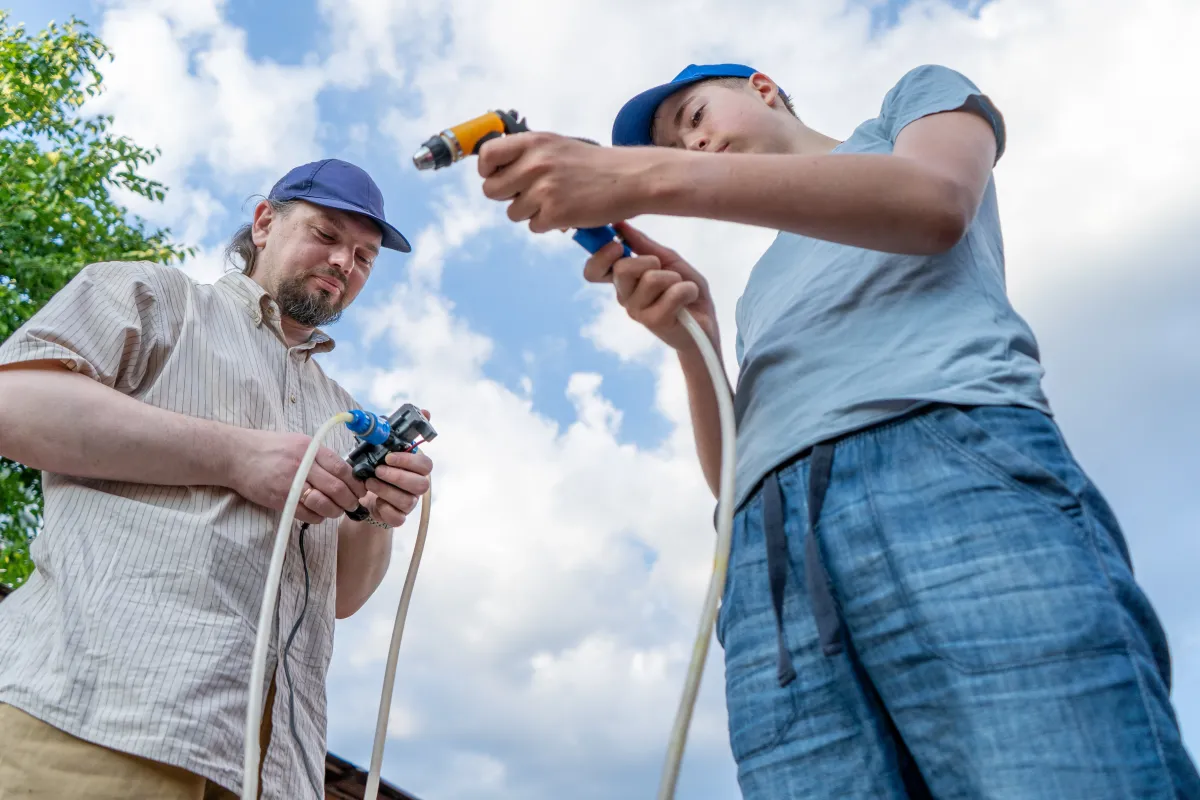 Family-owned plumbing company team preparing equipment for service work outdoors.