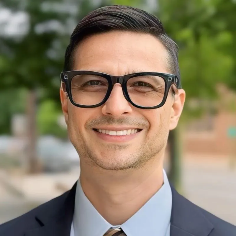 Shankar Poncelet smiling in a suit outoors