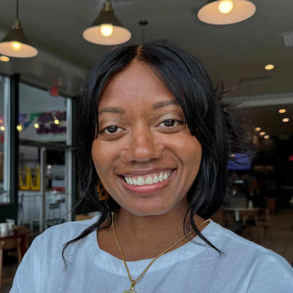 Antréa Ferguson smiling in a cafe in a white shirt