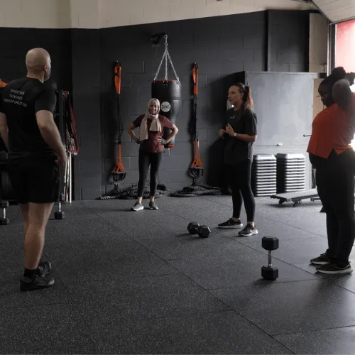 Coach Mody leading a small group strength training session at Stable Strength Oxford