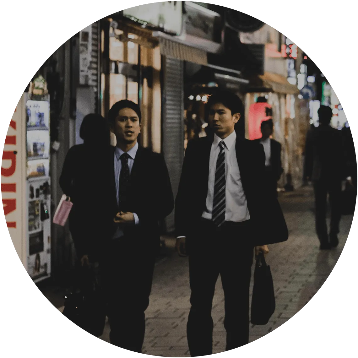 Business professionals walking in an Asian city at night, showcasing local market expertise.