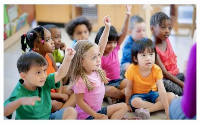 Kids moving with the teacher on a large screen TV
