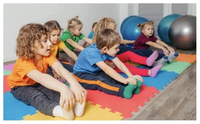 Boy holding a tambourine while watching the teacher on his tablet