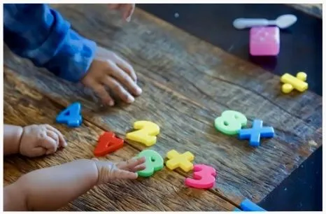 Boy picks paper out of different colored liquids