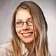 A young woman wearing glasses and smiling, reflecting fullpayout's positive payout reviews.