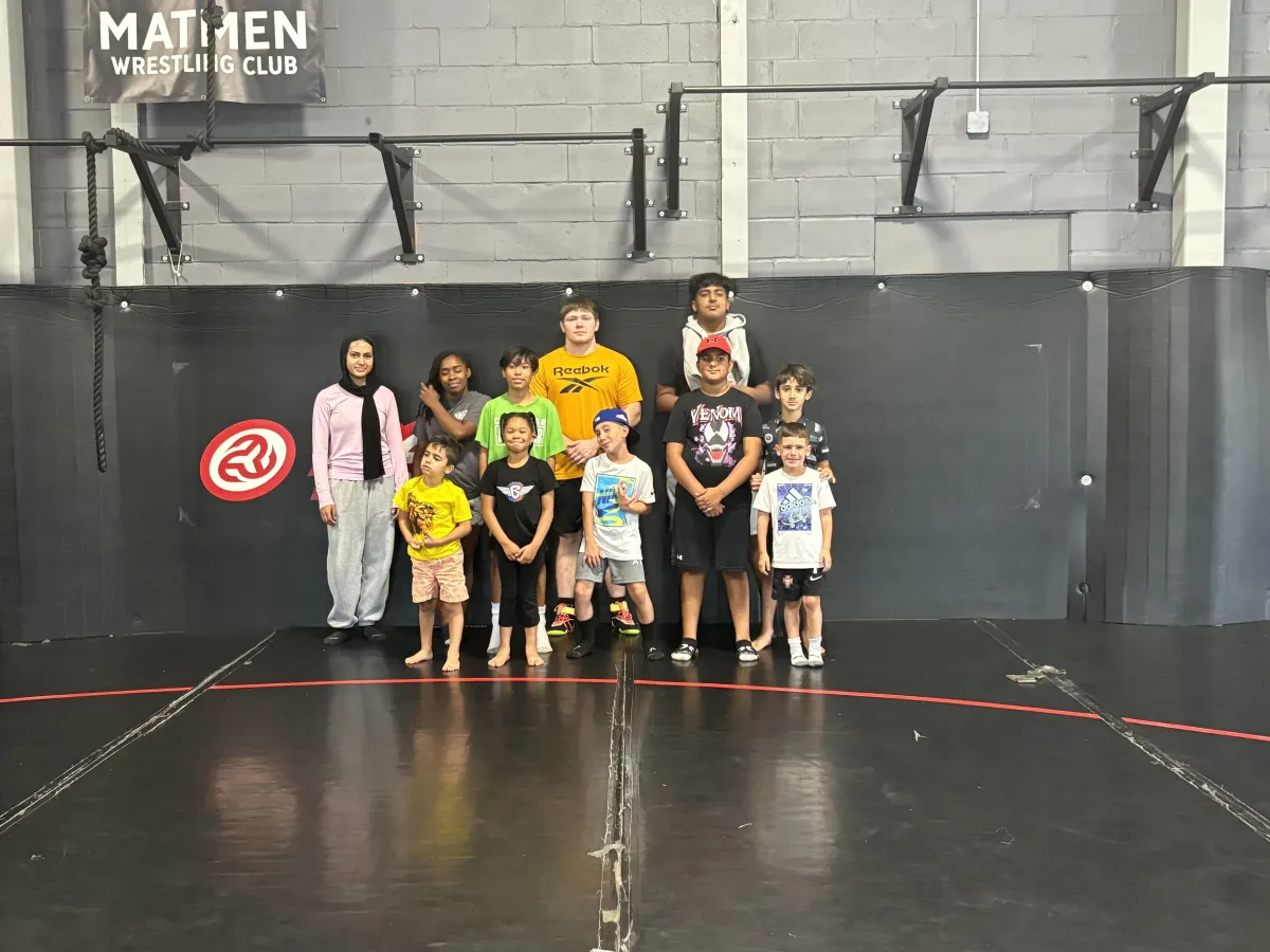 Parents greeting children at camp pick-up with staff present, cheerful and organized environment
