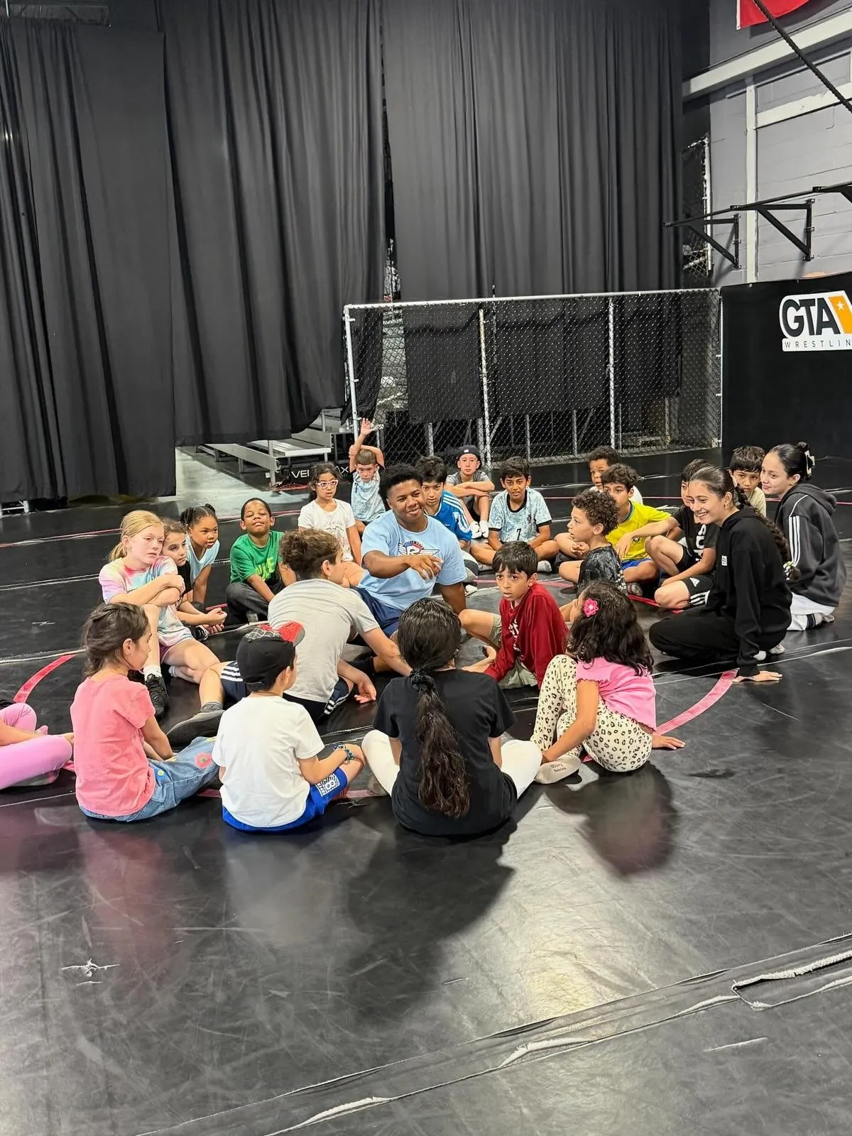 Three diverse children smiling and holding martial arts belts