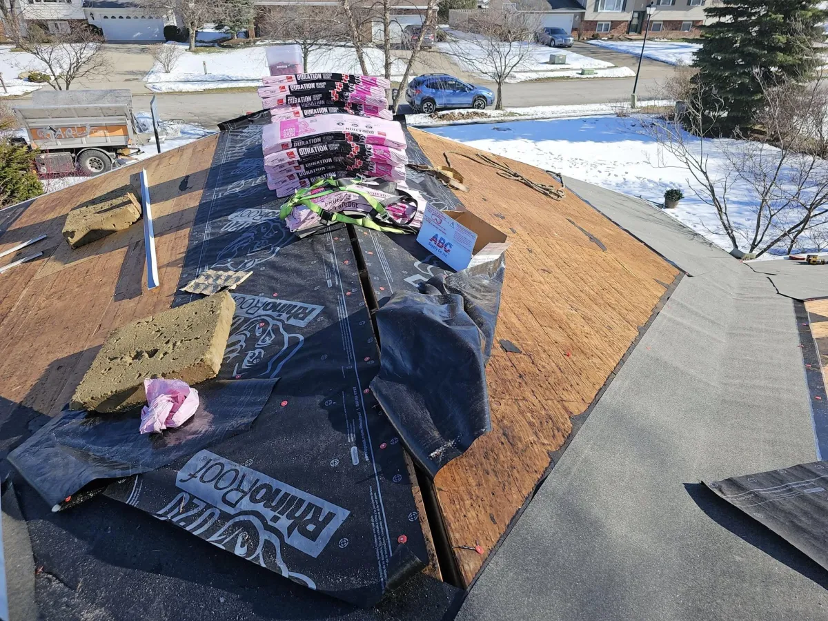 Owens Corning Duration shingles being installed during full roof replacement in snowy Ohio neighborhood