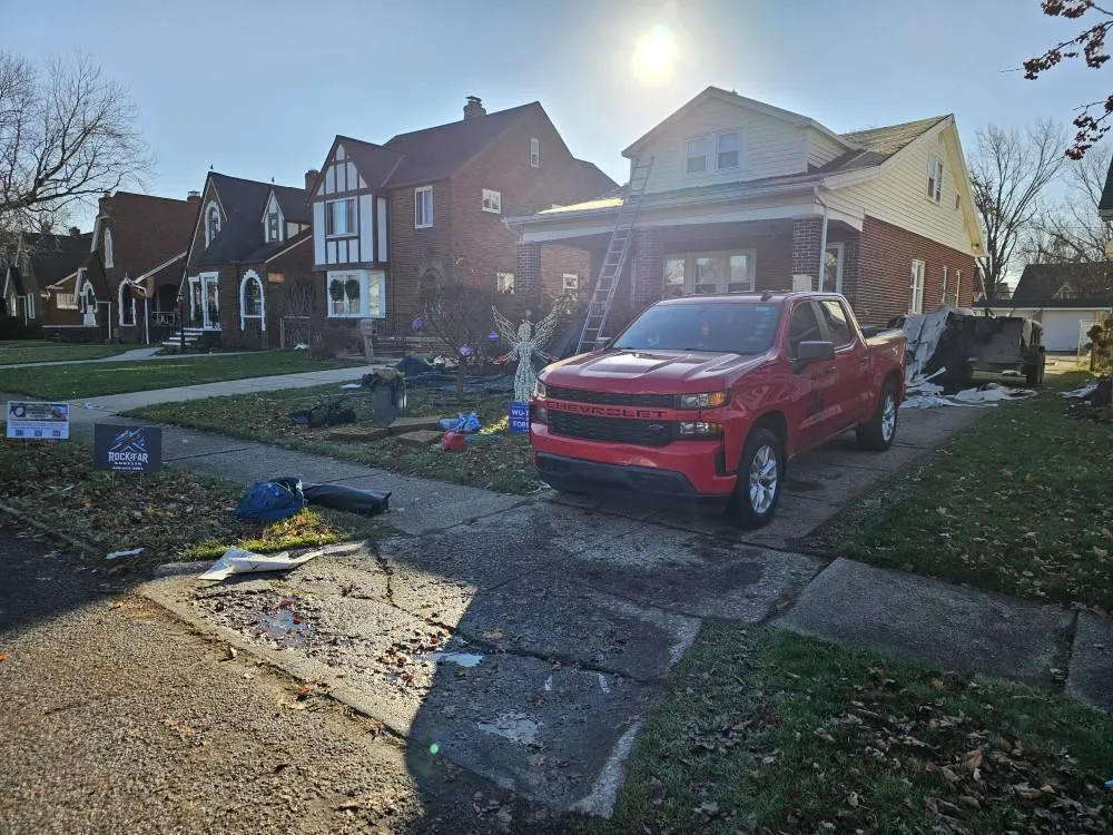 Roofing project underway in Geneva, Ohio by Rockstar Roofing – complete home roof replacement with crew and debris trailer on site