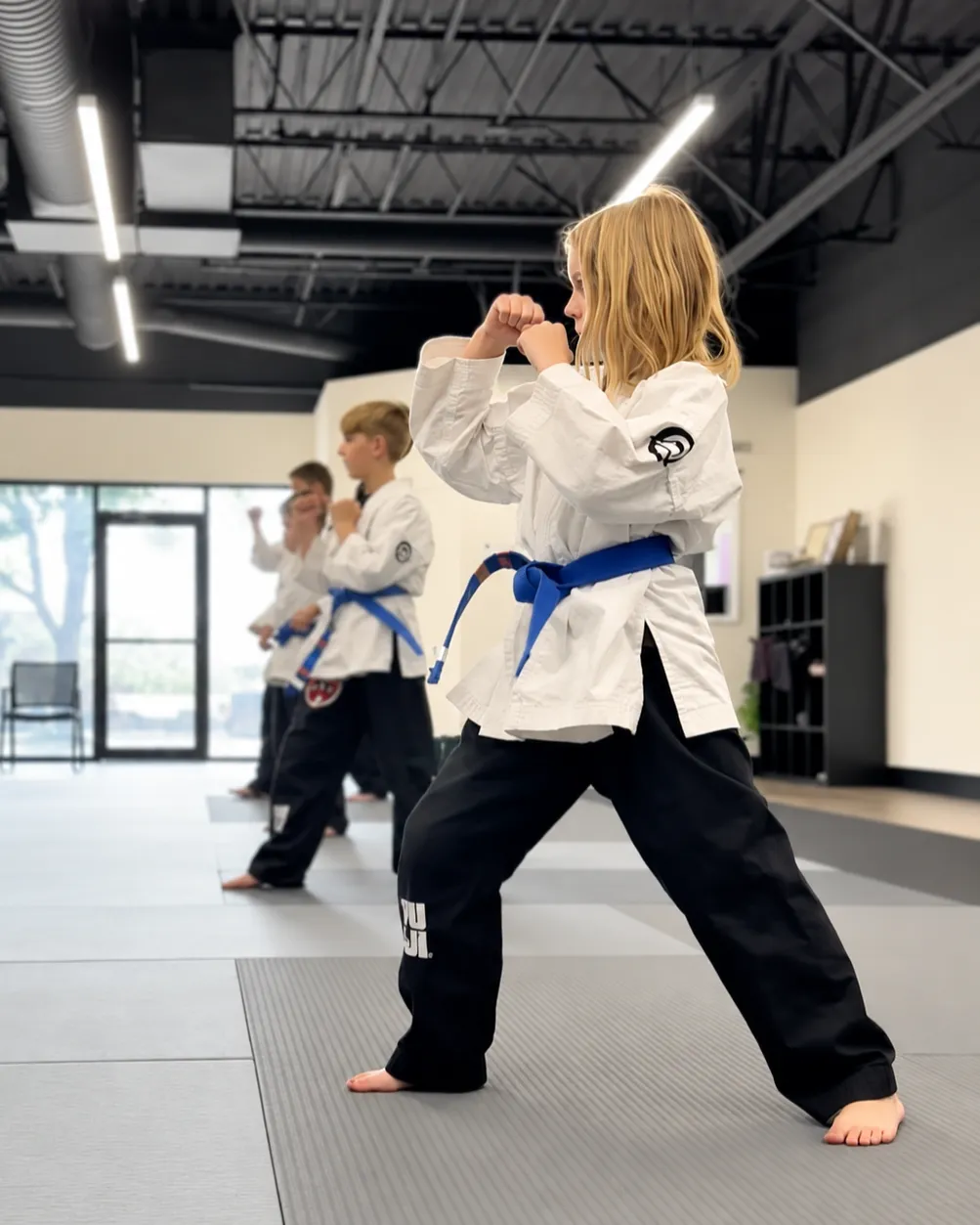 Preschool martial arts student practicing kick