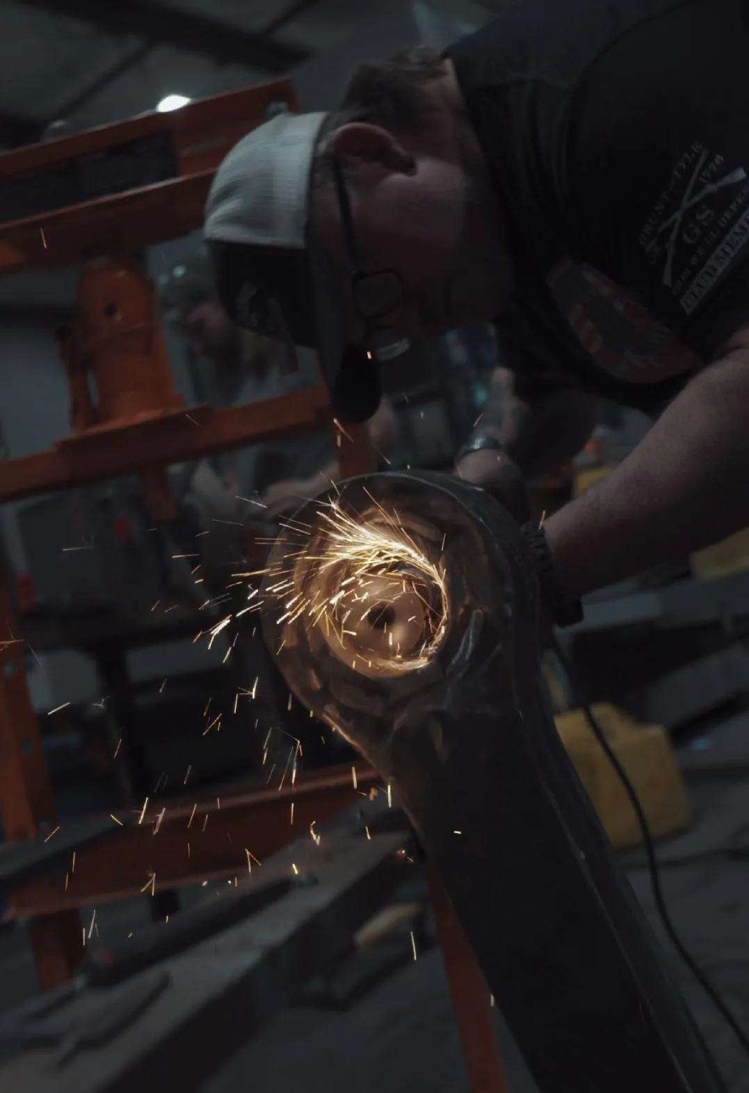 Fabricator working on metal with a circular spark pattern at CNC Syndicate's shop in Ravenswood, WV, showcasing professional metal fabrication and welding services
