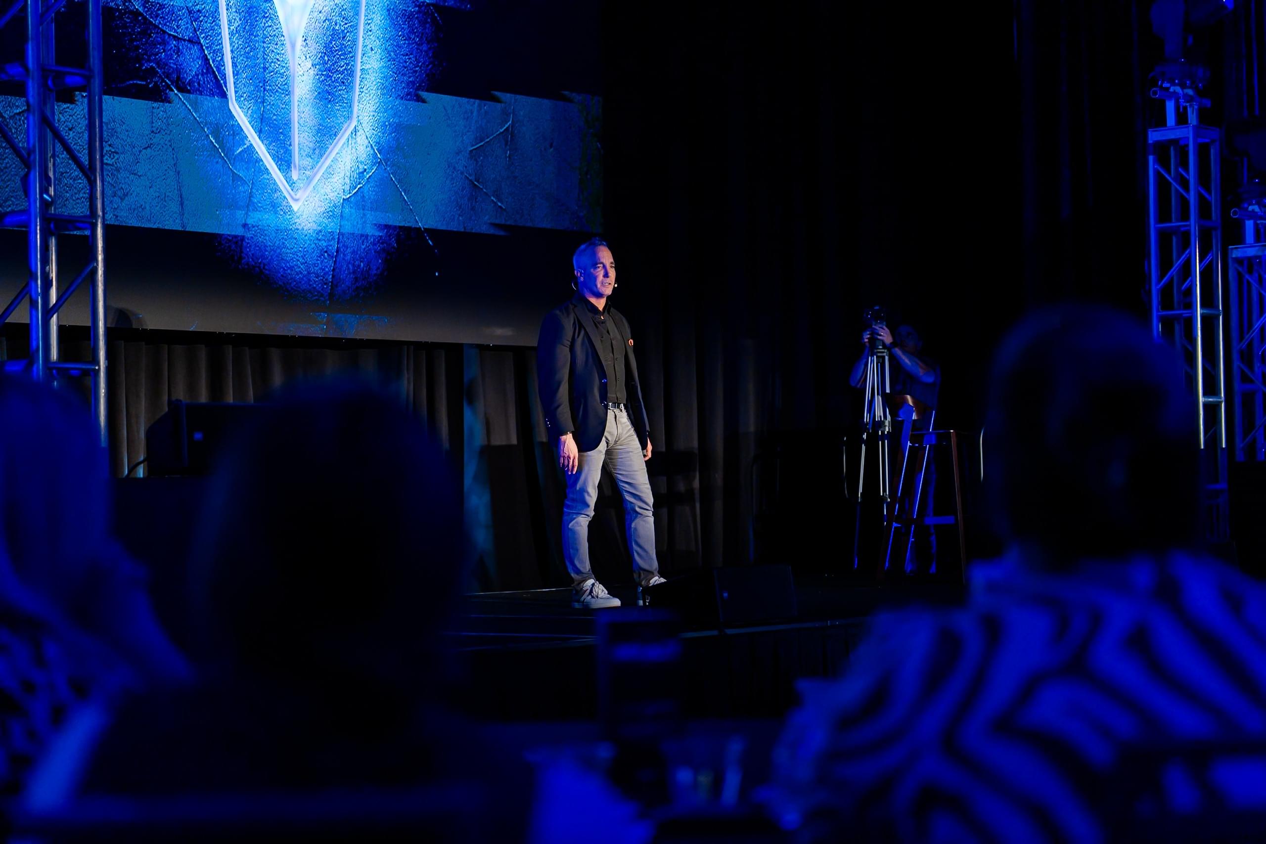 Eric J. Morin Speaking on Stage in front of a room full of dentists