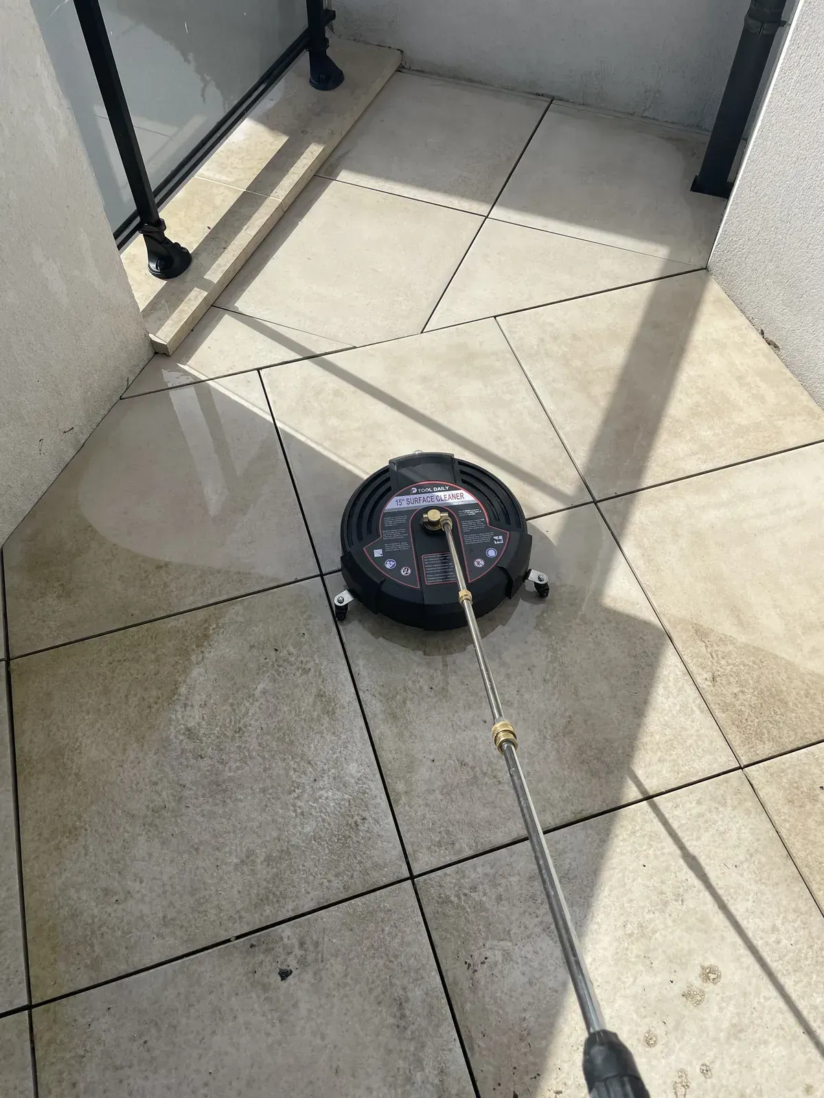 Nettoyage de terrasse en cours à Caen : la zone traitée retrouve sa teinte d'origine face à la partie encore encrassée