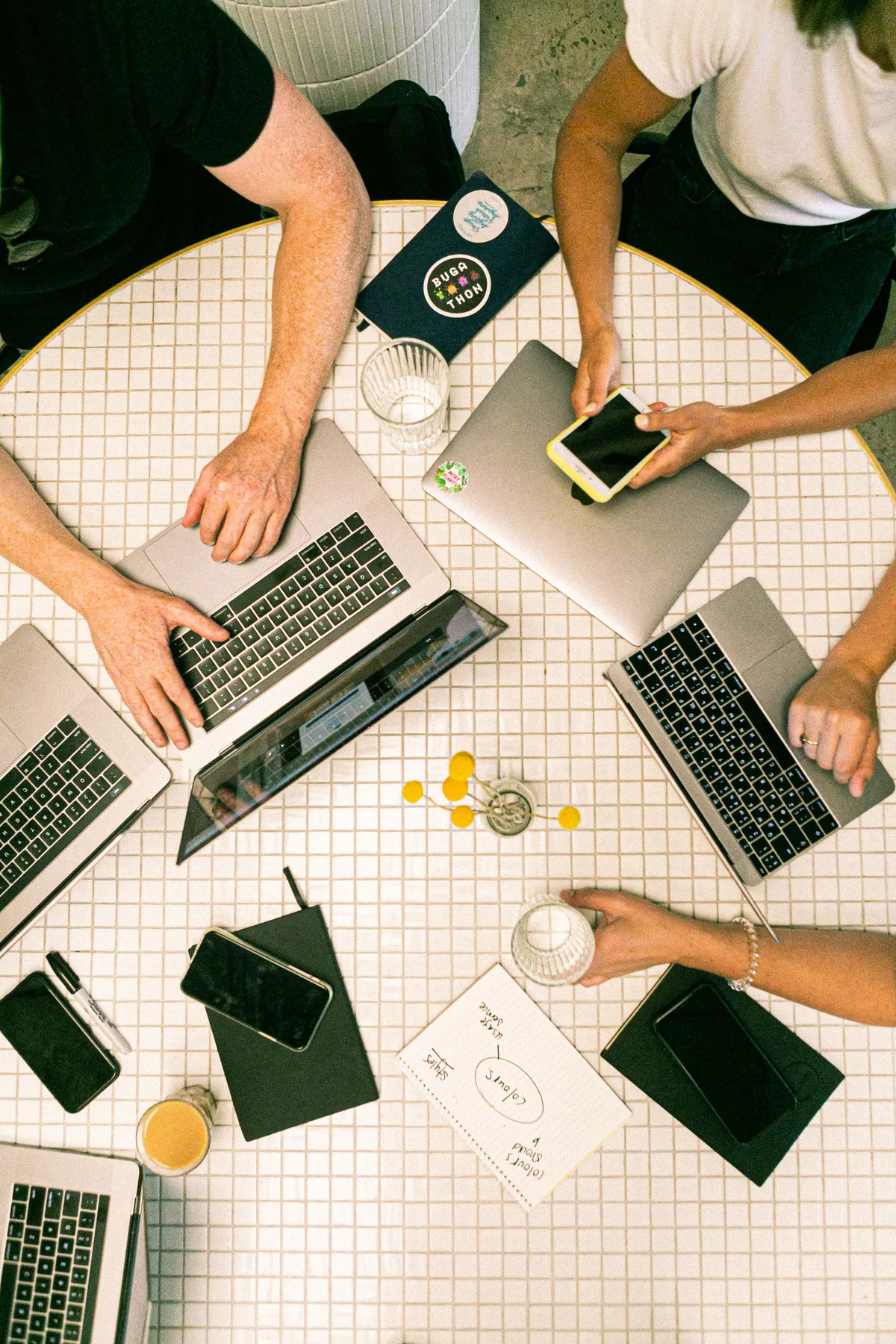 group-of-people-on-laptops-collaborating-around-a-table
