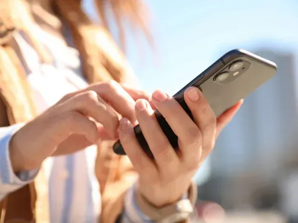 Trash bin cleaning technician washing garbage bin at the curb