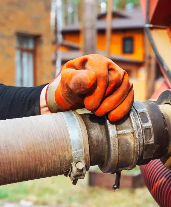 Close-up of worker connecting vacuum hose for septic pumping service