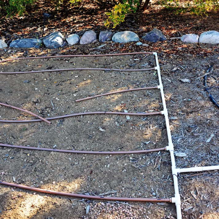 A technician repairing a broken sprinkler hose in an Austin yard, preventing water waste and promoting landscape health.