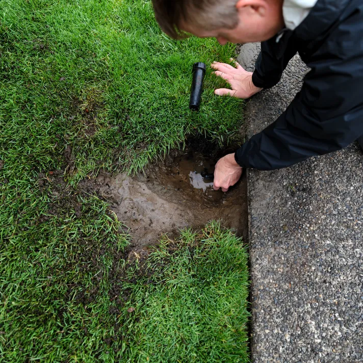 A specialist conducting a thorough assessment of a sprinkler system in Austin, evaluating its efficiency and coverage.