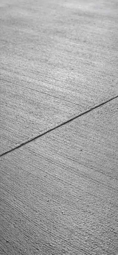 Newly replaced smooth concrete driveway in Arlington TX with precise edges, lush lawn, garden, and modern home.