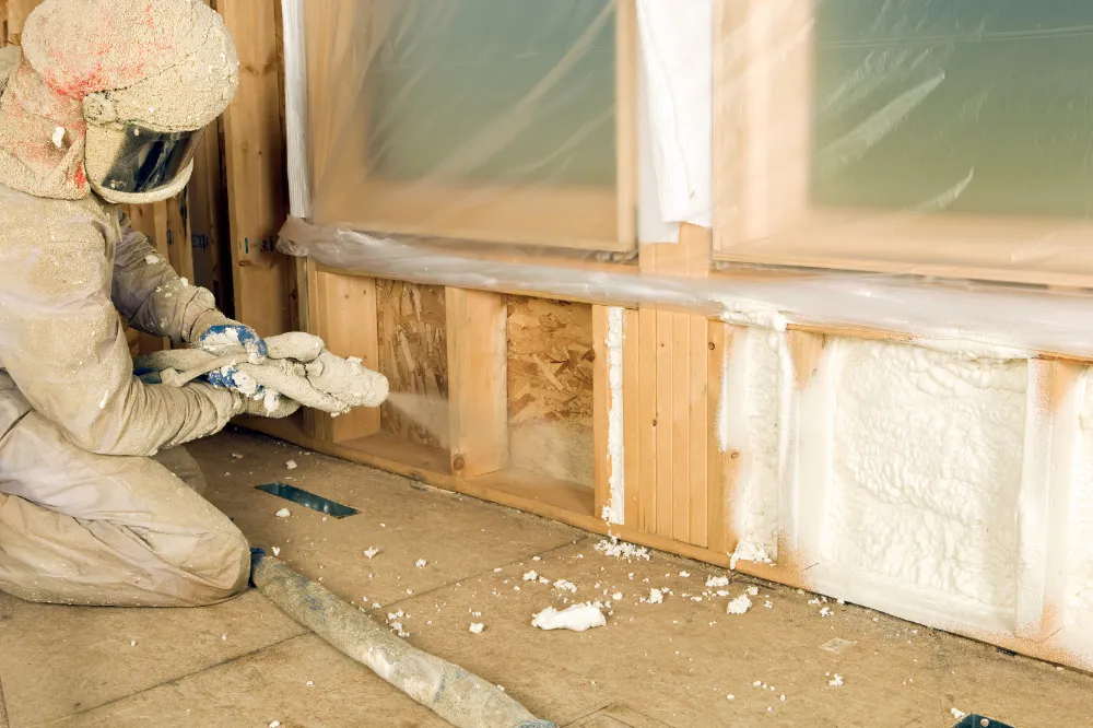 Worker spraying foam insulation