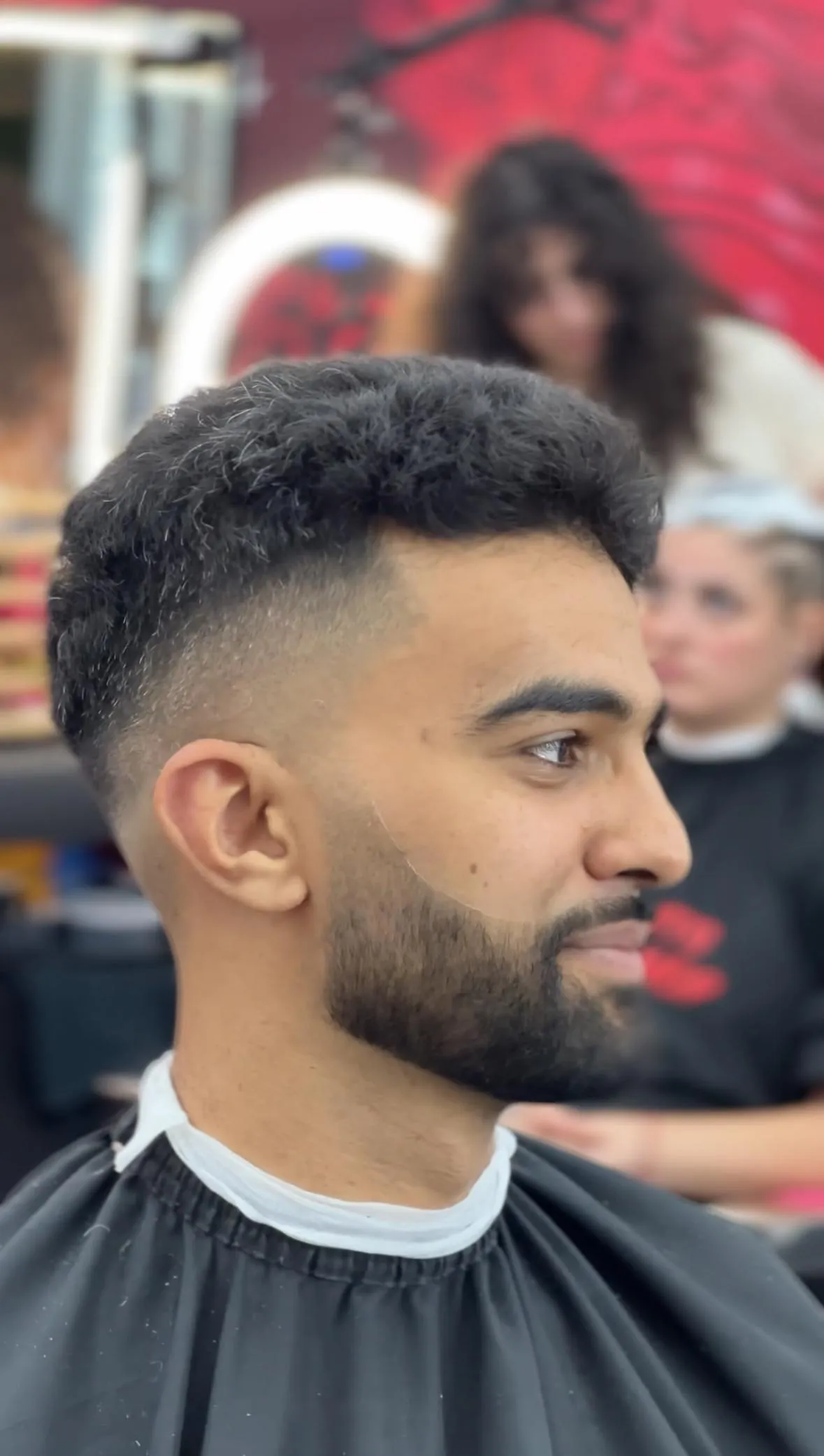 A man standing in front of a barber shop