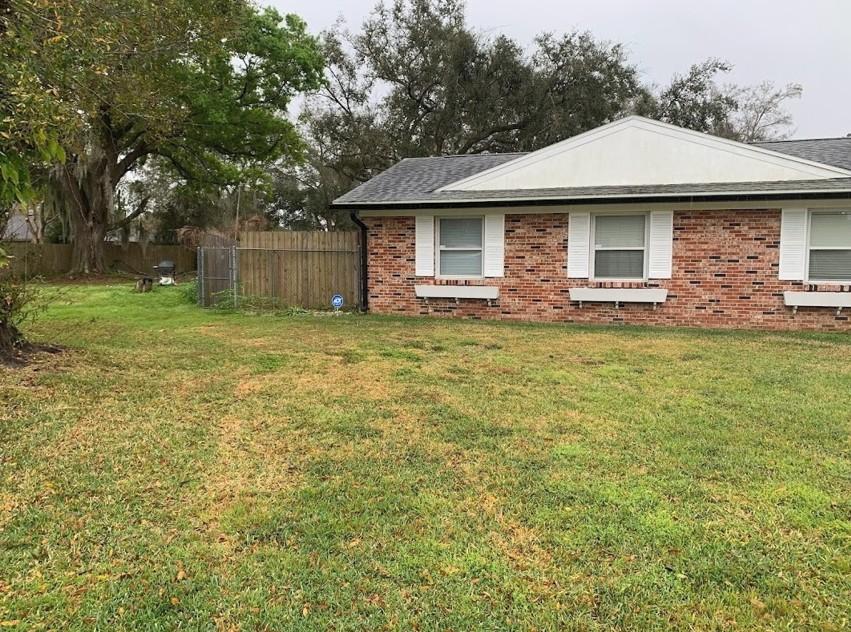 Neatly cut front yard in front of a red brick home with trimmed edges