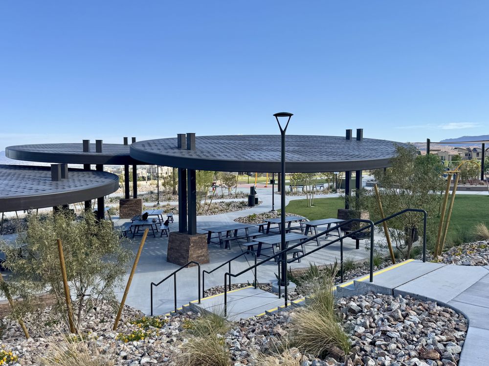 Modern shaded picnic pavilion and landscaped community park area in Summerlin West Las Vegas with walking paths, desert landscaping, and mountain views.