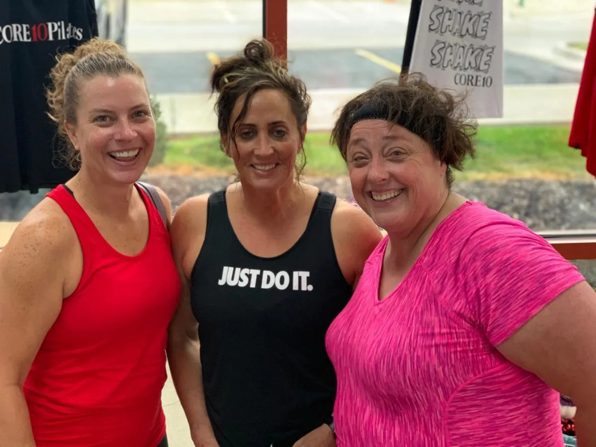 Three happy Core10 Pilates members of different ages, smiling and showcasing a welcoming, supportive fitness community for all levels