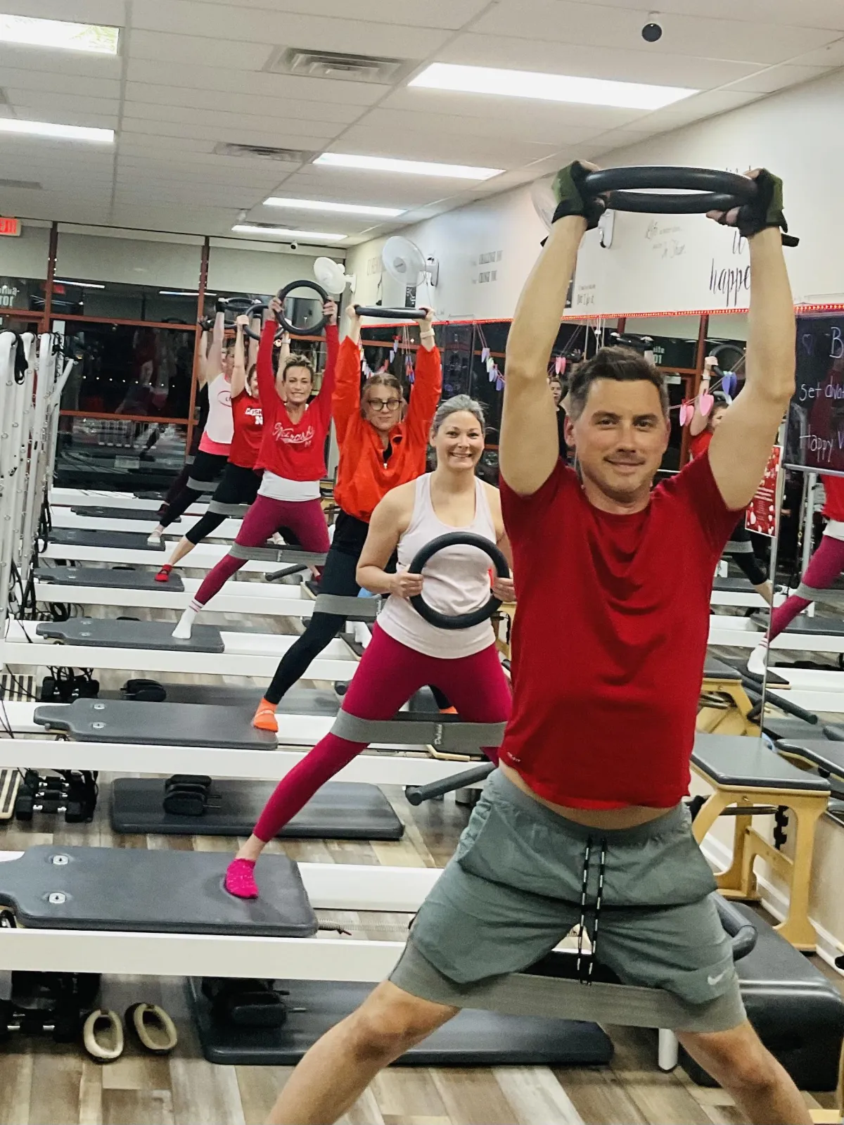 Core10 Pilates members doing a full-body reformer workout using dumbbells in a high-energy group class in West Omaha.