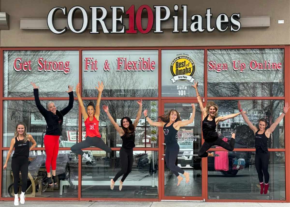 Core10 Pilates instructors in West Omaha posing and jumping together outside the studio