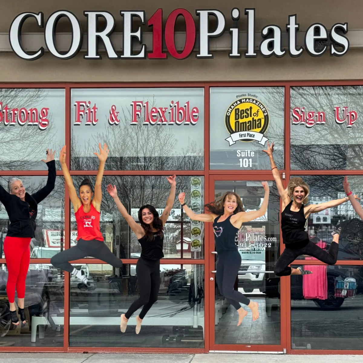 Core10 Pilates instructors jumping with excitement in front of the studio, celebrating strength, community, and high-energy reformer workouts