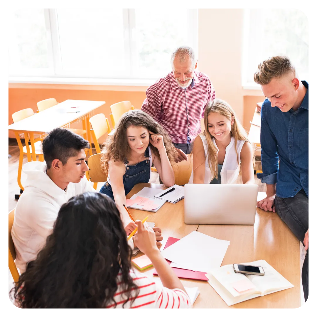 Students collaborating on a project at Aspire Incubator, guided by a mentor in a bright and engaging classroom setting.