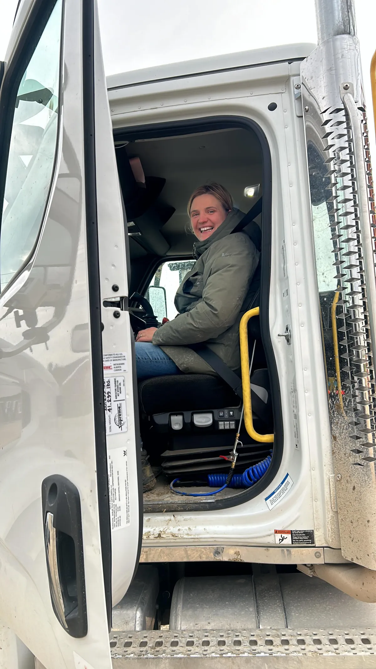 Diverse group of families and children participating in a farm tour at Rosegaar Dairy, with interactive displays, smiling faces, and a backdrop of green fields and barns.