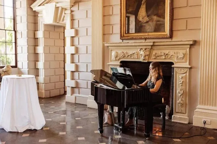 Wedding guests enjoying champagne and canapes while Vanessa plays contemporary acoustic piano